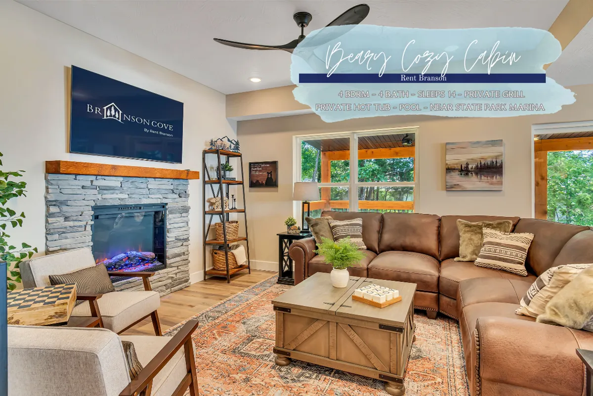 This interior image showcases a welcoming living room with a cozy fireplace, a plush sofa, a coffee table, a TV, and wall artwork. The inviting arrangement suggests a space perfect for relaxing, gathering, and enjoying both quiet moments and lively game nights.